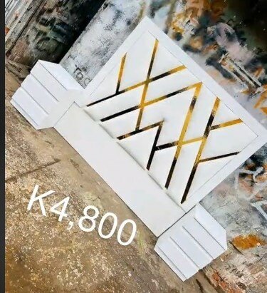 The headboard of the bed is soft, white with gold