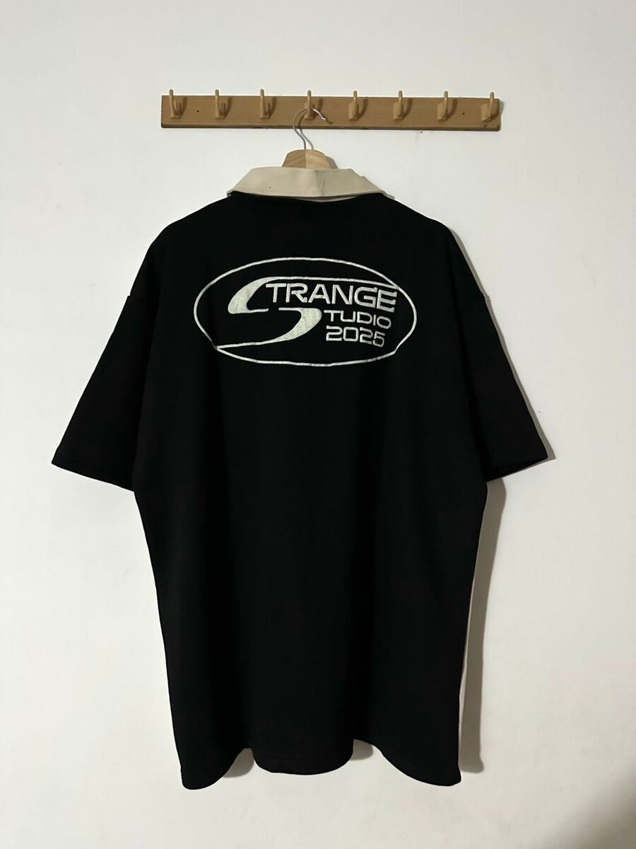 Polo noir Strange Studio 2025