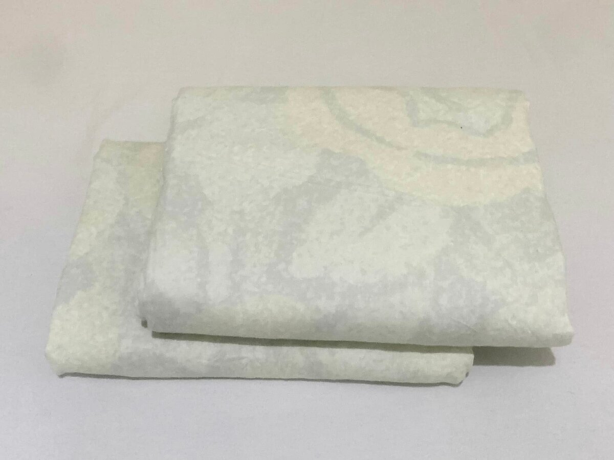 A set of light beige bed linen with a delicate textured pattern