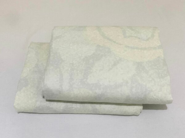 A set of light beige bed linen with a delicate textured pattern