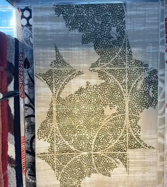 Carpet with an abstract natural pattern (green leaves and geometric lines on a beige background)