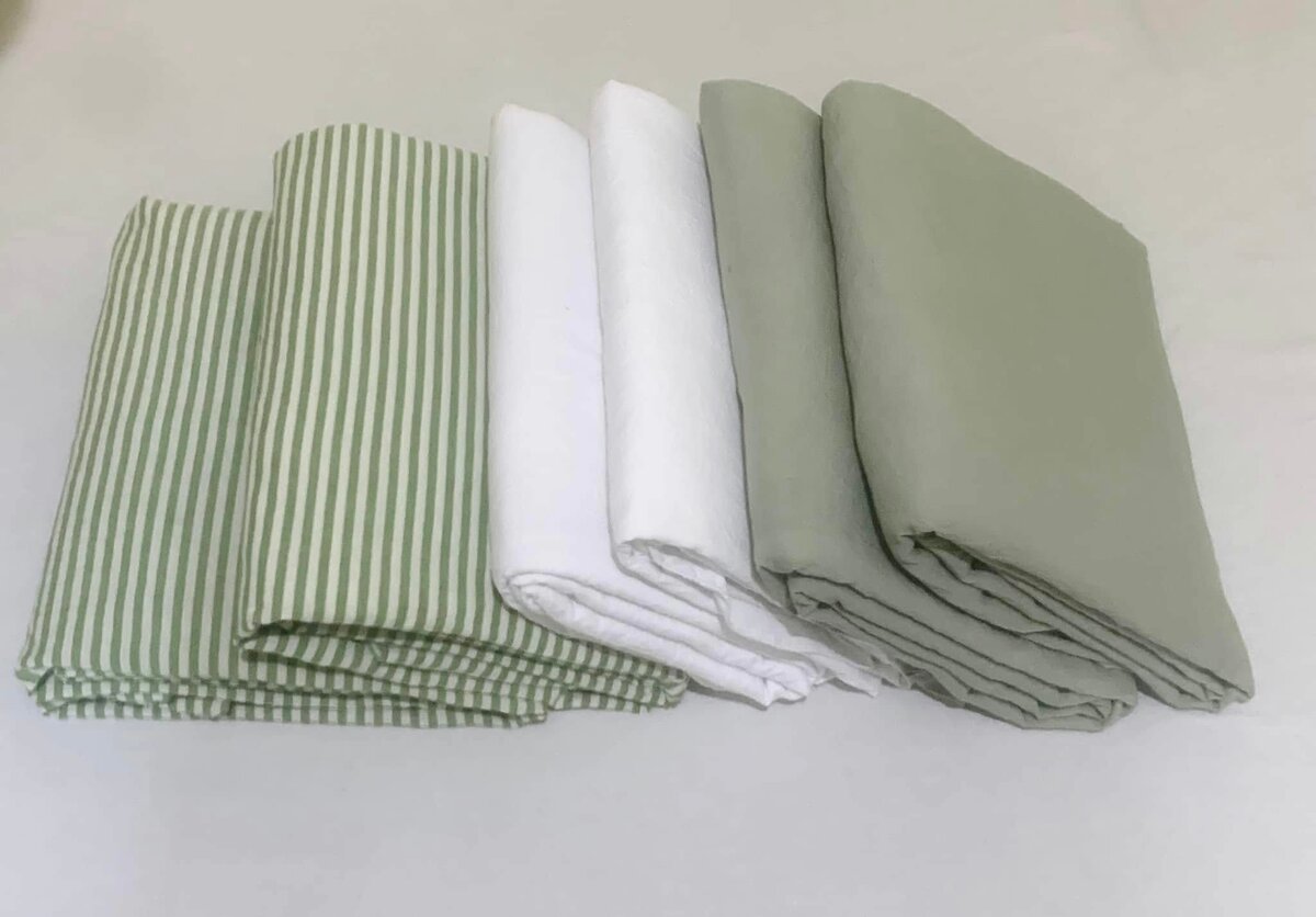 A set of bed linen in soft green and white shades with a striped pattern