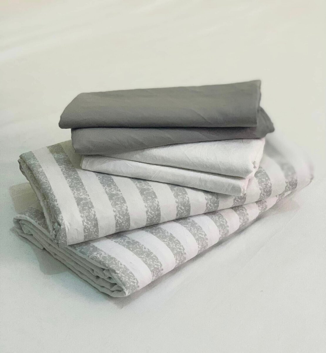 A set of bed linen in gray and white tones with a striped pattern