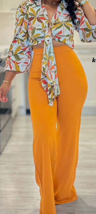 Women's set with floral print blouse and orange trousers.