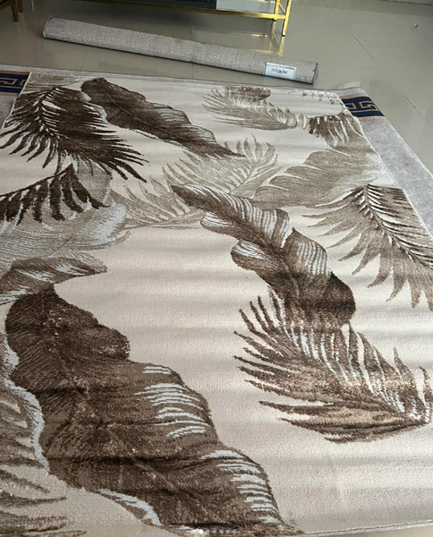 A carpet with a voluminous pattern of palm leaves in beige-brown tones