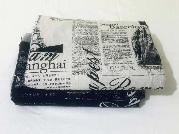 Bed linen printed with cities and newspaper texts.