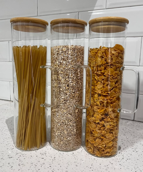 A set of glass containers for storing food, with bamboo lids and handles