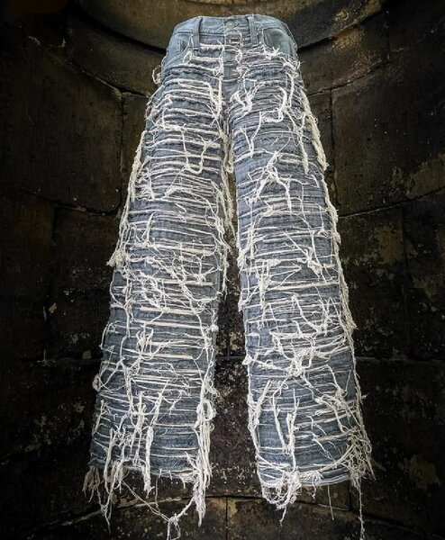 Jean déchiré avec fil blanc