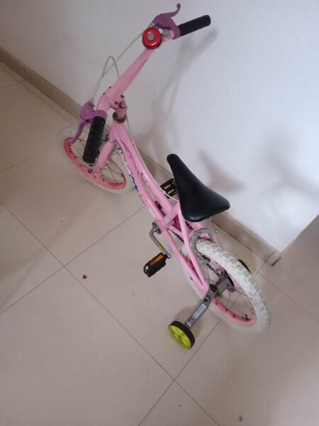 Pink bicyle with bell/horn and training wheels
