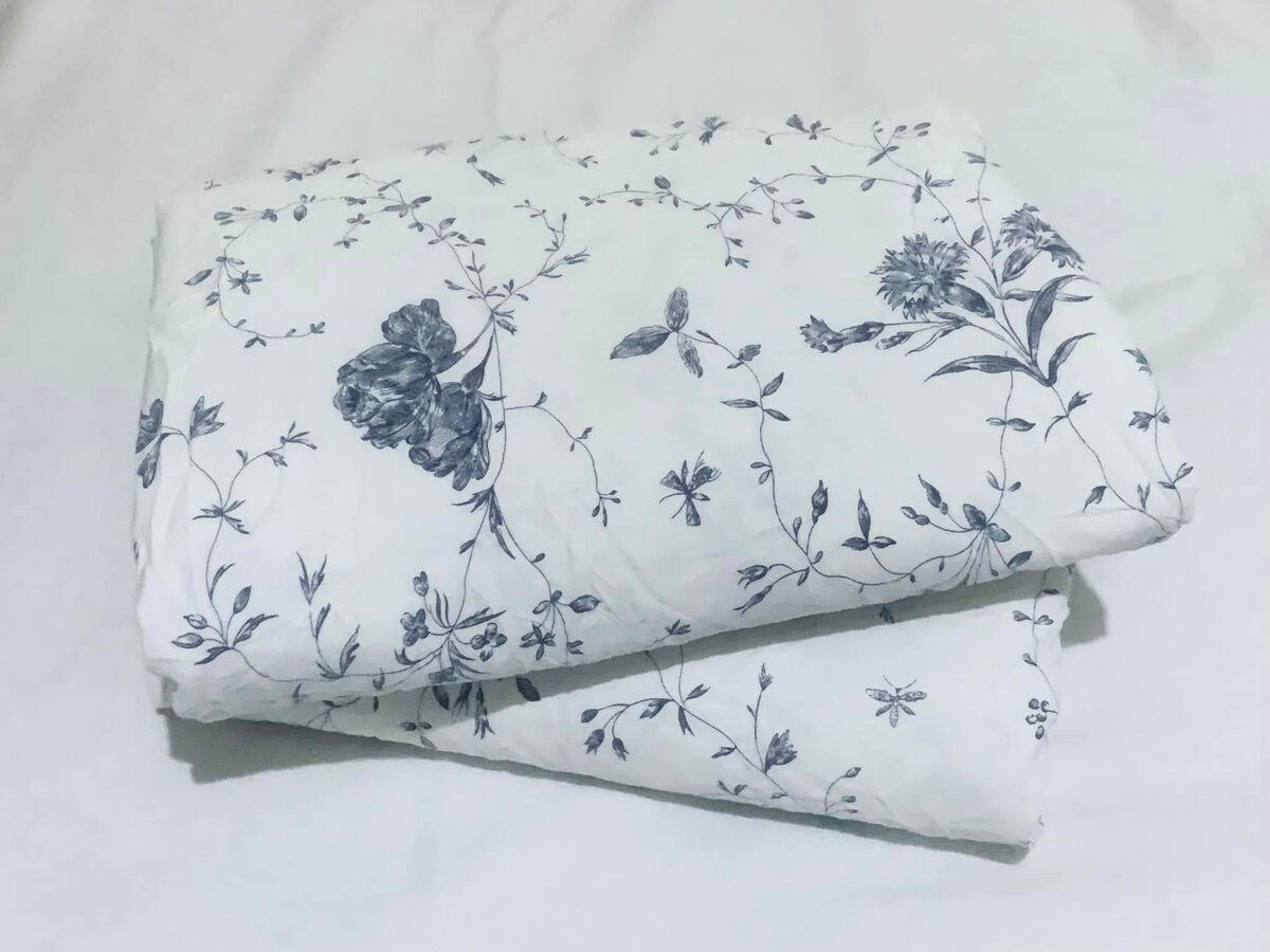 A set of bed linen with a blue floral pattern on a white background