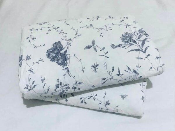 A set of bed linen with a blue floral pattern on a white background