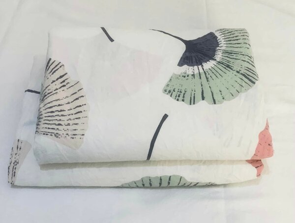 Bed linen with a leaf pattern in pastel colors.