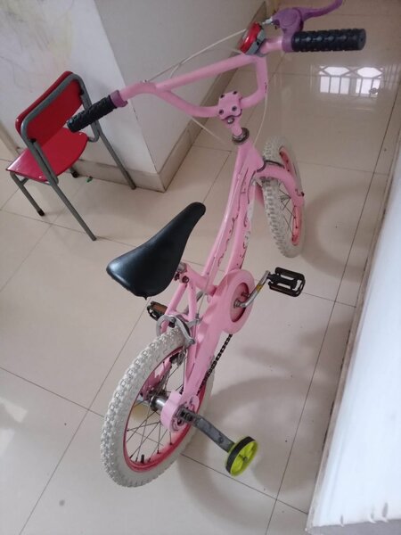 Pink bicyle with bell/horn and training wheels