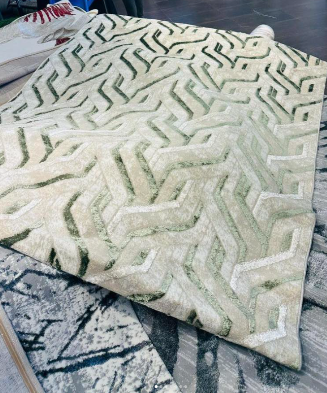 A carpet with a voluminous geometric pattern in light green and beige tones