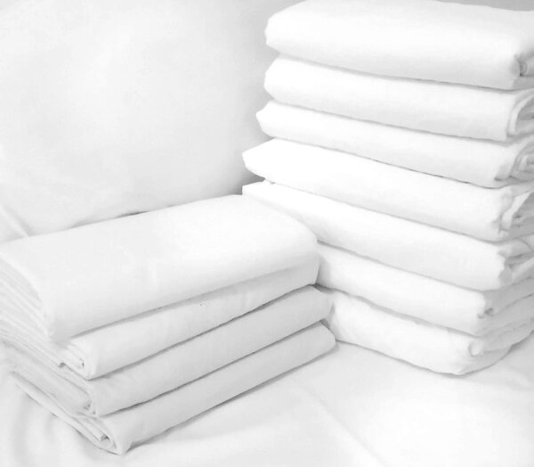A set of snow-white bed linen: piles of pillowcases and sheets