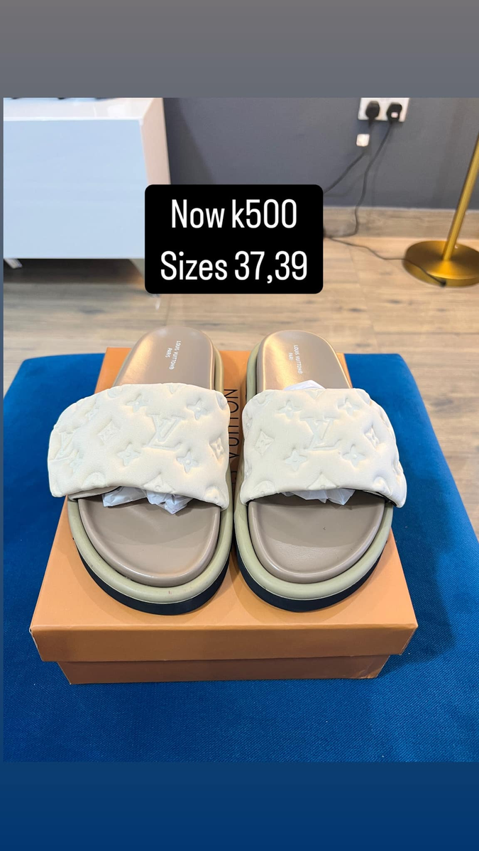 grey and white flip-flops with YSL logos