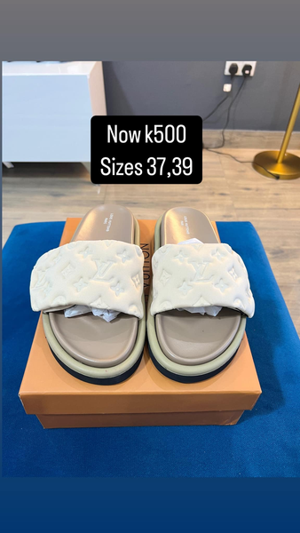 grey and white flip-flops with YSL logos