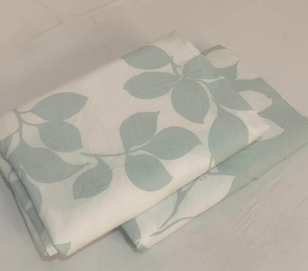 A sheet with a print of green leaves on a white background