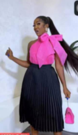 Robe avec jupe plissée noire et haut sans manches rose avec nœud et col fermé