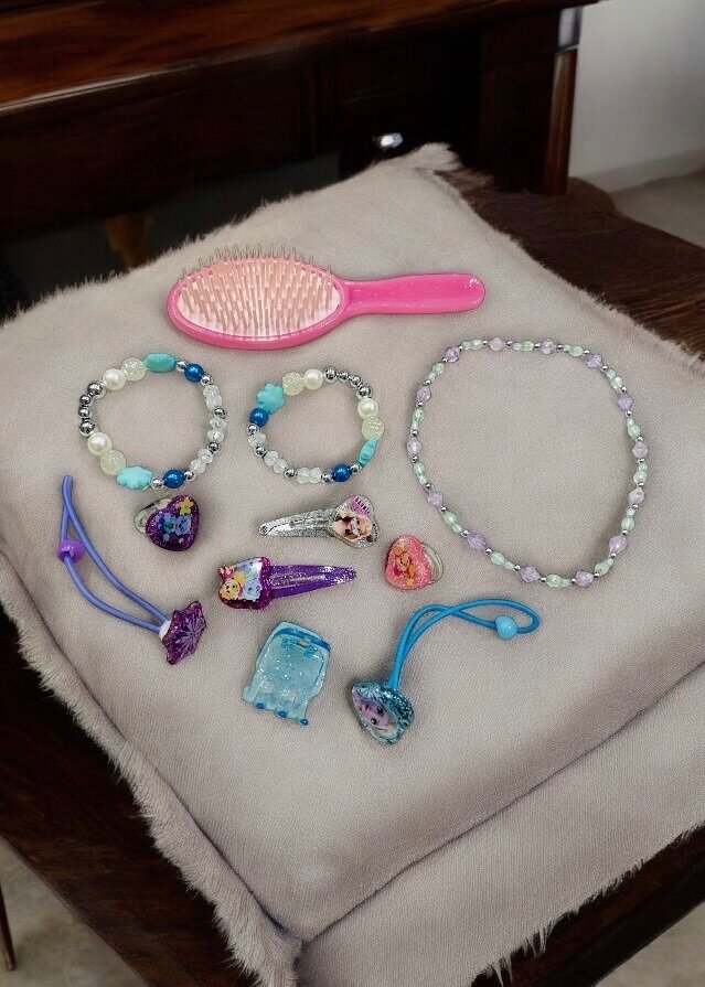 Pink bag with hair accessories and jewelry for kids.