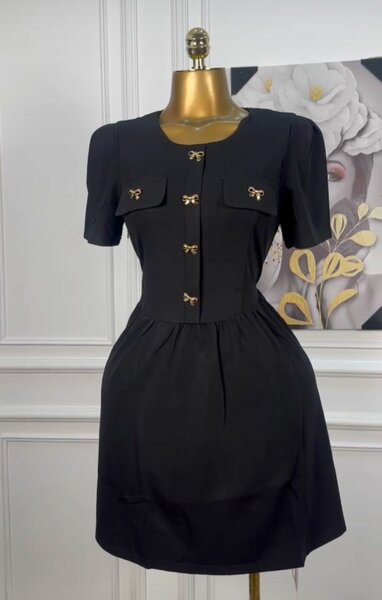 Robe élégante noire avec boutons dorés