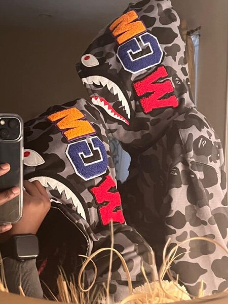 Grey hoodie with black camouflage print, shark-style hood and bright stripes, unisex