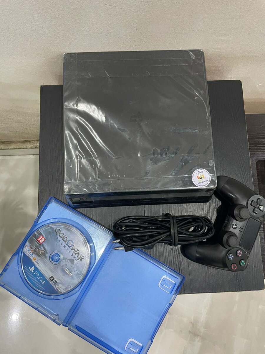 Ps4 slim avec une manette et un CD