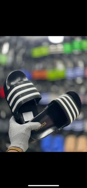 Men's black Adidas flip-flops with white stripes, made of synthetic material