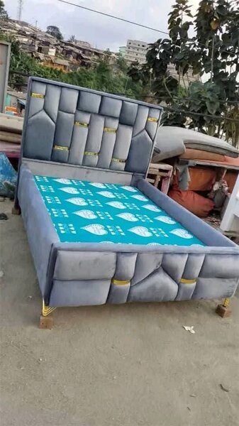 Lit gris avec tête de lit capitonnée