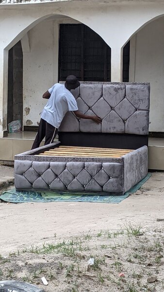 Lit gris capitonné avec tête de lit