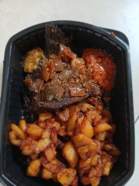 Repas de poisson frit et bananes plantains